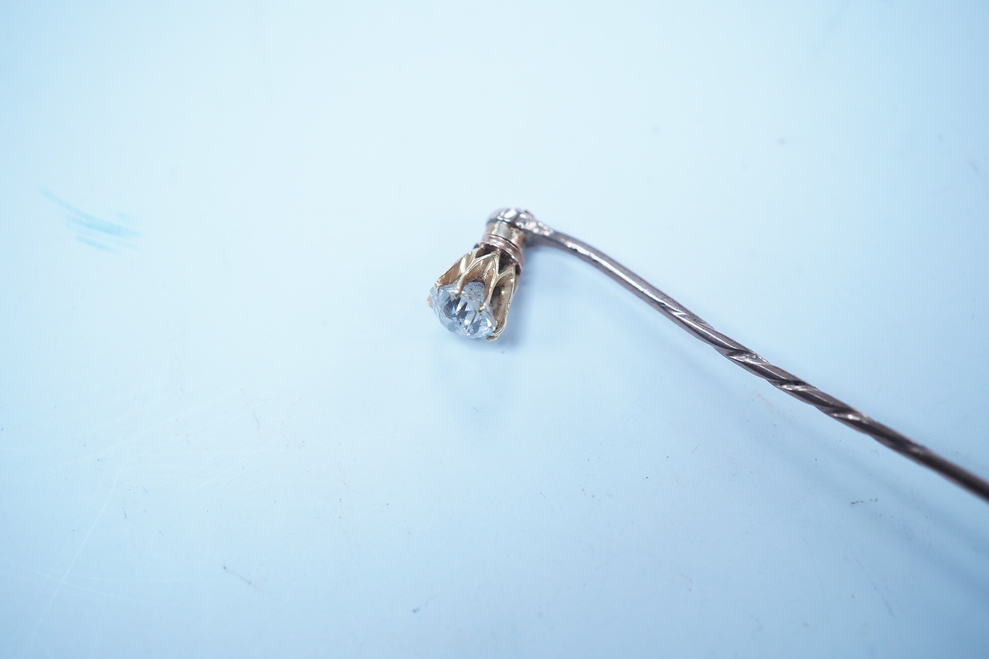 A yellow metal and solitaire diamond set stick pin, the stone diameter approx. 5mm, 59mm, gross weight 2.3 grams. Condition - fair to good